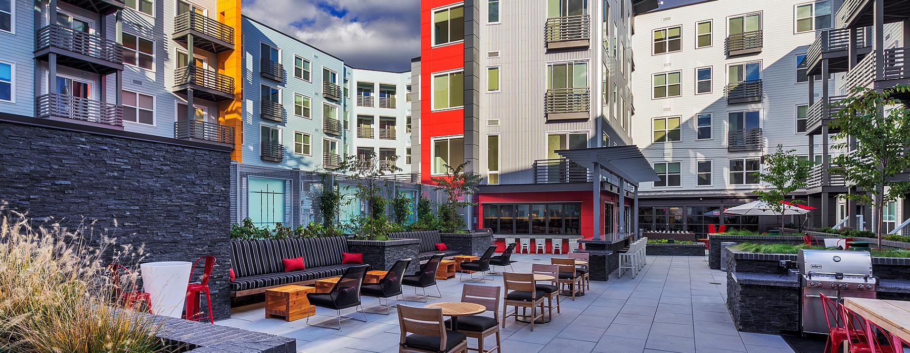 a group of buildings with tables and chairs outside