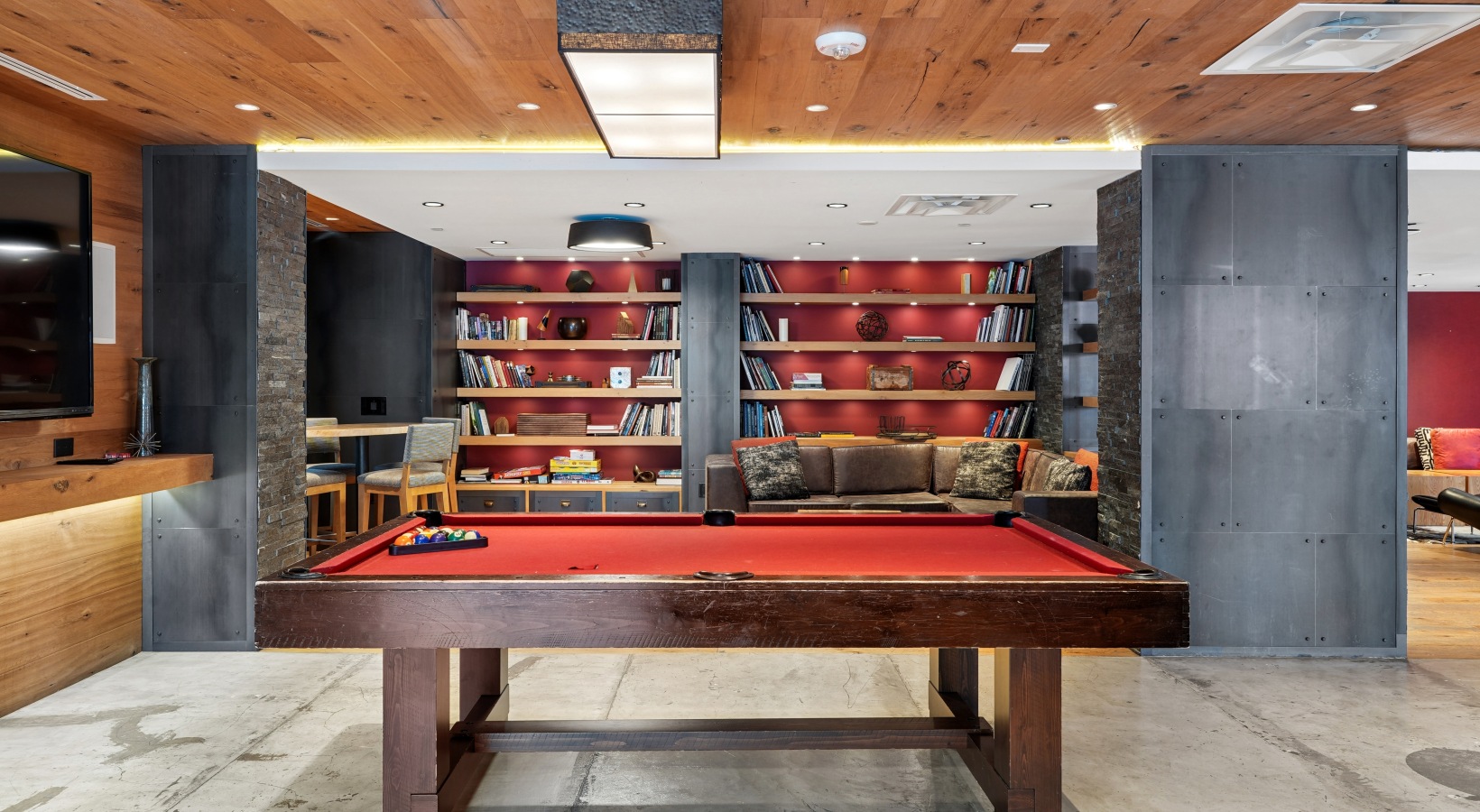 a room with a table and shelves and a billiards table